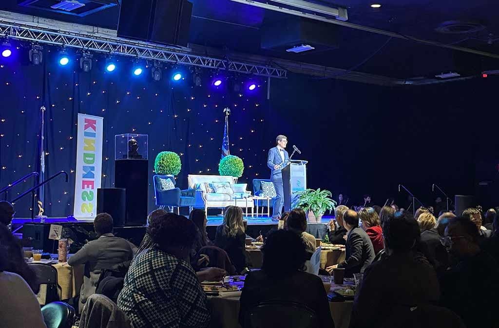 President Hopkins stands on a stage smiling and presenting at the Spartanburg Unity breakfast.